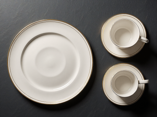 Elegant ceramic dinnerware set, white porcelain with gold trim, arranged plates and bowls
